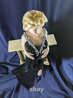 Franklin Mint Marilyn Monroe porcelain doll standing against a Fireplace